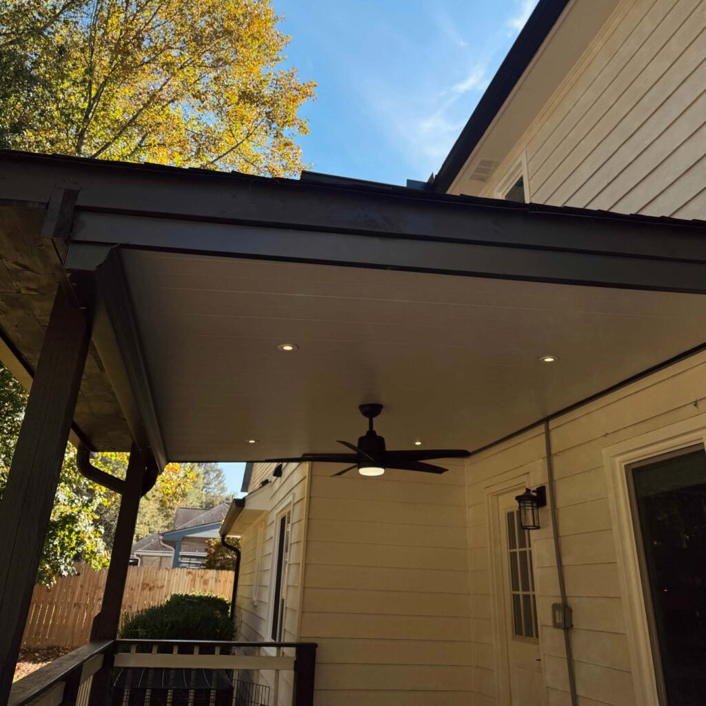 Covered backyard patio with ceiling fan and recessed lighting attached to a house
